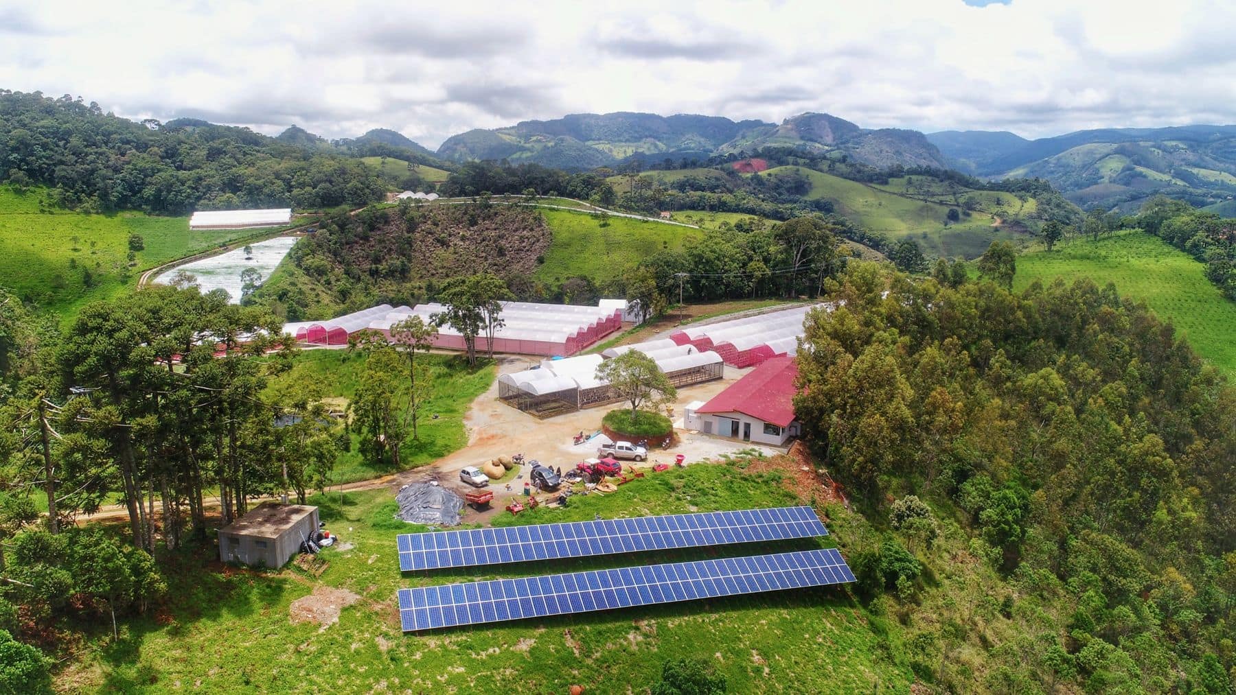 Vista aérea da Fazenda do Retiro, com as hortas e as montanhas ao fundo